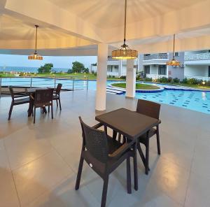 a patio with tables and chairs and a pool at Luxury Beachfront apartment at Baobab Waves in Mombasa