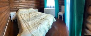 a bedroom with a bed and a wooden wall at La Escondida in Estación Monte