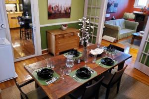 a dining room table with plates and glasses on it at The Red Rooster Bungalow in Asheville