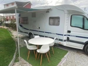 a white caravan with a table and chairs at Autocaravana Dethleffs Globetrotter in Viana do Castelo