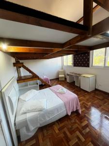 a bedroom with a large bed and a wooden floor at DM Thermas Hotel Iraí in Iraí