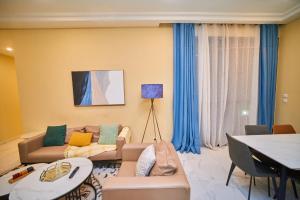 a living room with a couch and a table at Résidence Akia - Jacuzzi privé & détente moderne in Pointe-Noire