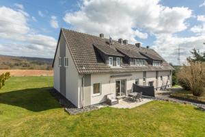 a house with a pitched roof on a green field at Ferienwohnung Waldeck am Edersee in Waldeck