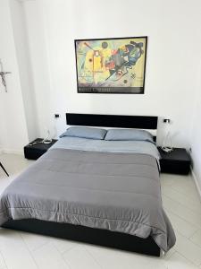 a bedroom with a bed and a painting on the wall at AragonApartment in Santa Maria a Vico