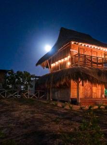 a building with a thatch roof at night at Playa Escondida Mayapo in Mayapo