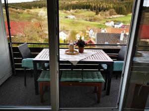 a table and chairs on a balcony with a view at Ferienwohnung Blick Rappenstein in Hausen am Tann