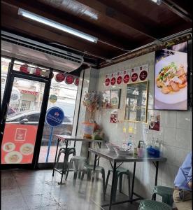 a restaurant with tables and chairs in front of a window at Boonlert Egg Noodle in Bangkok