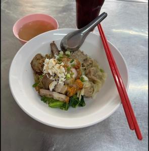 a white plate of food with meat and vegetables at Boonlert Egg Noodle in Bangkok