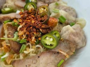 a plate of food with pasta and vegetables on it at Boonlert Egg Noodle in Bangkok