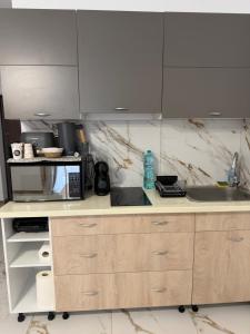 a kitchen with a sink and a microwave at Apartament DAR25 in Sînmartin