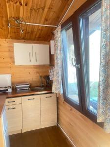 a kitchen with a large window in a log cabin at Zacisze 6 osobowy Domek nad jeziorem in Świętne