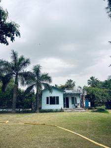 a house with two palm trees in the yard at CASA NOVA Villa in Noida