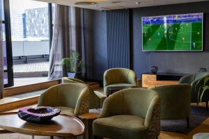 a waiting room with chairs and a tv on the wall at Onyx Studio Apartment in Cape Town