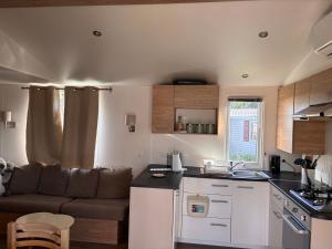 a kitchen and living room with a couch in a room at Camping siblu in Lattes