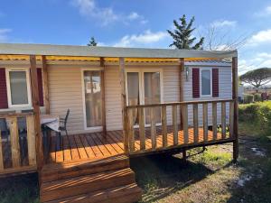 a house with a porch and a deck at Camping siblu in Lattes