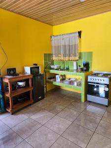 a kitchen with yellow walls and a stove at Rusticas Dani in Tanque
