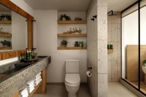 a bathroom with a white toilet and a sink at 1 Hotel Austin in Austin