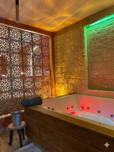 a large bathroom with a tub with a green light at La Casetta refuge méditerranéen et balnéo classé 3 étoiles in Wizernes +41 photos