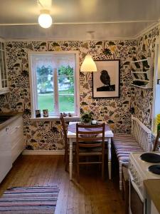 a kitchen with a table with chairs and a window at Flintegården Kårhus in Borgund