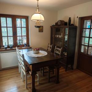 a dining room with a wooden table and chairs at Leśny Relaks in Krasiejów +11 photos
