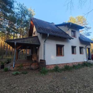 a small white house with a black roof at Leśny Relaks in Krasiejów