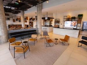 a lobby with chairs and tables and a bar at Ibis Votuporanga in Votuporanga