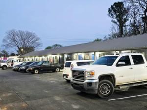 a white truck parked in a parking lot in front of a store at Chek Inn Motel Rockingham NC in Rockingham
