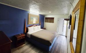 a bedroom with a bed and a blue wall at Chek Inn Motel Rockingham NC in Rockingham +16 photos