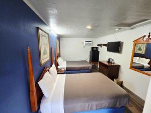 a small room with two beds and a tv at Chek Inn Motel Rockingham NC in Rockingham
