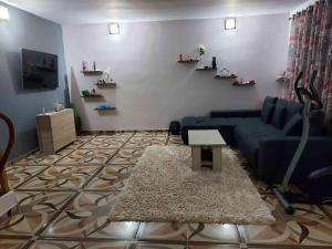ein Wohnzimmer mit einem blauen Sofa und einem Teppich in der Unterkunft Dalila in Corbu