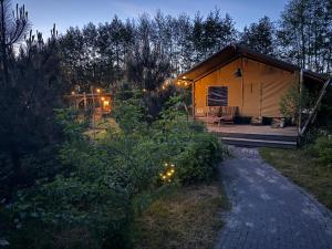 a large tent with a patio in a garden at night at The Love Nest in Heelweg
