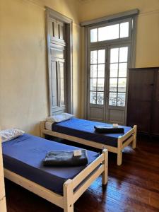 two beds in a room with a window at Colmena Hostel Rosario in Rosario