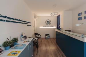 a room with a kitchen with a counter and chairs at Dimore delle Zagare Ortigia in Syracuse +78 photos