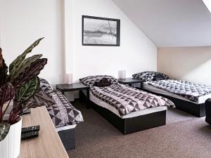 a bedroom with two beds and a potted plant at Apartmány Žalák in Ostrava