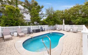 a swimming pool with chairs and a white fence at Ritz Clareon by Oversee 30A in Seacrest