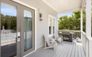 a white porch with a grill and chairs on it at Ritz Clareon by Oversee 30A in Seacrest