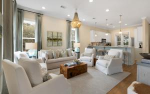 a living room with white furniture and a kitchen at Ritz Clareon by Oversee 30A in Seacrest