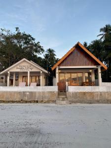 a building with two chairs in front of it at JOSEPHA COTTAGE in Ngurblut +20 photos