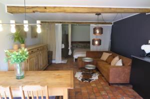 a living room with a couch and a table at La maison de Barbara in Aubel