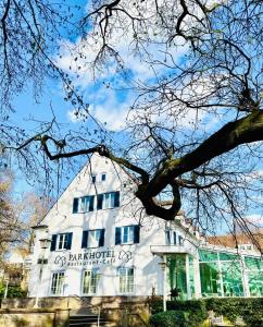a white building with a sign on it at Parkhotel Steimker Berg Wolfsburg in Wolfsburg
