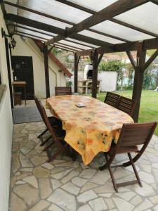 a table and chairs under a pergola on a patio at Le Chant des Grenouilles in Itteville