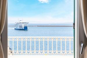 a boat in the water viewed from a window at Domo Cicindela Boutique Rooms Centro Carloforte in Carloforte