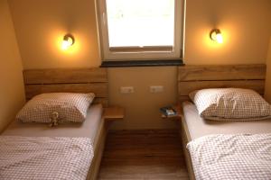 two beds in a room with a window at Weserberglandalm in Ottenstein