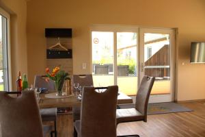 a dining room with a table and a glass door at Weserberglandalm in Ottenstein +16 photos
