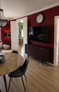 a living room with a table and a clock on a wall at Apartment Mare in Rostock