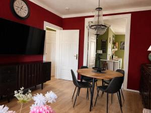 a dining room with a table and chairs and a clock at Apartment Mare in Rostock