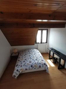 a bedroom with a bed and a desk in a attic at Le Chant des Grenouilles in Itteville
