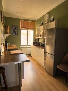 a kitchen with a stainless steel refrigerator and a table at Apartment Mare in Rostock