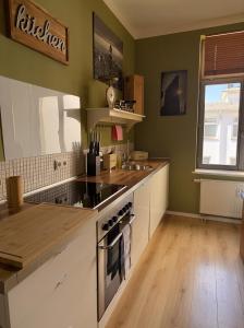 a kitchen with green walls and a stove top oven at Apartment Mare in Rostock