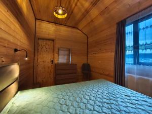 a bedroom with a bed and a large window at Pinewood Surami in Surami